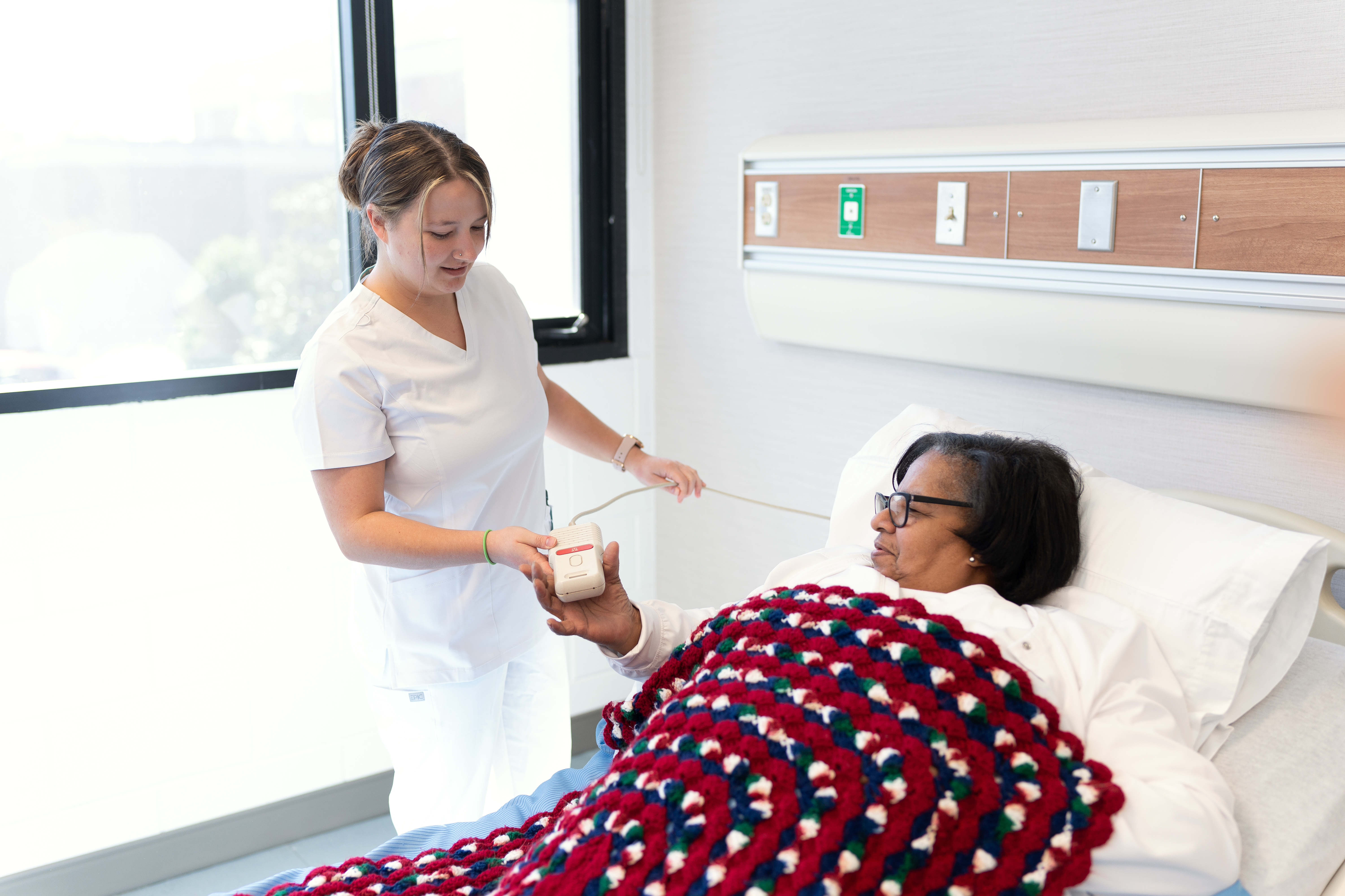 Nursing aide student practices patient care techniques on a training patient during a classroom lab exercise.