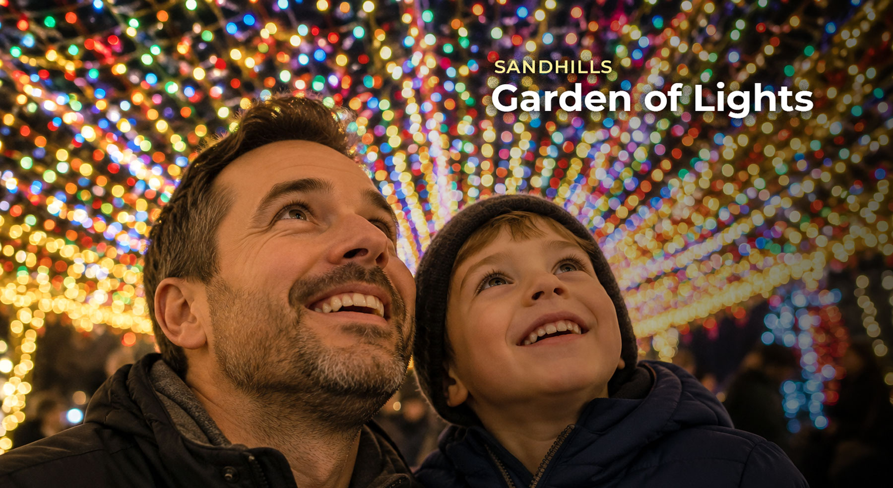 A father and child look up in wonder beneath a canopy of colorful holiday lights at the Sandhills Garden of Lights.