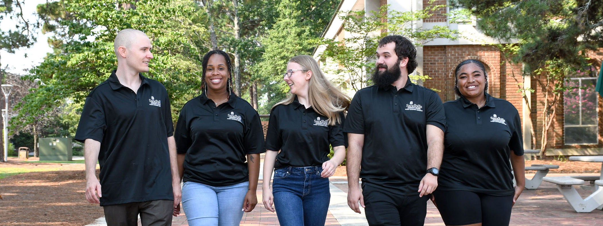 Student Government Association Members Walking on Campus Five Student Government Association members walk together along a brick pathway on the Sandhills Community College campus.