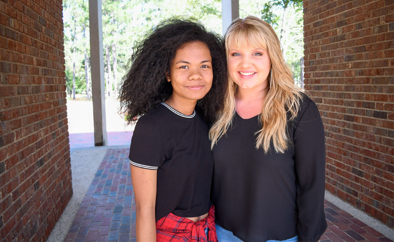 Two students posing on campus