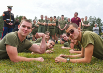 JROTC cadets in olive green uniforms hold plank positions on the grass while flexing and smiling during the Viking Drill Meet at Sandhills Community College.