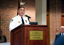 Chief Nicholas Polidori of the Southern Pines Police Department speaks at a podium during a graduation ceremony at Sandhills Community College.
