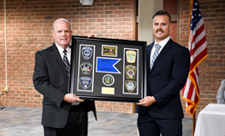 Basic Law Enforcement Training graduates present a framed class gift to BLET Director Ron Turk during a ceremony at Sandhills Community College.