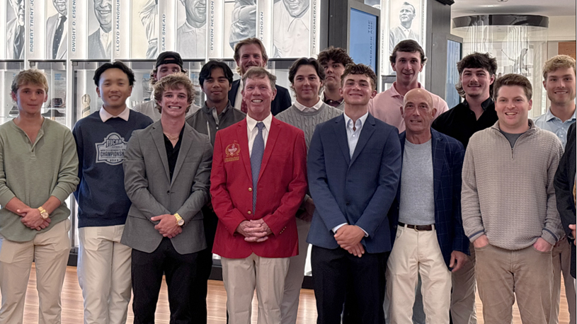 Golf coach Gus Ulrich, wearing a red Flyers Championship Jacket, poses with current and former SCC golfers at the World Golf Hall of Fame.