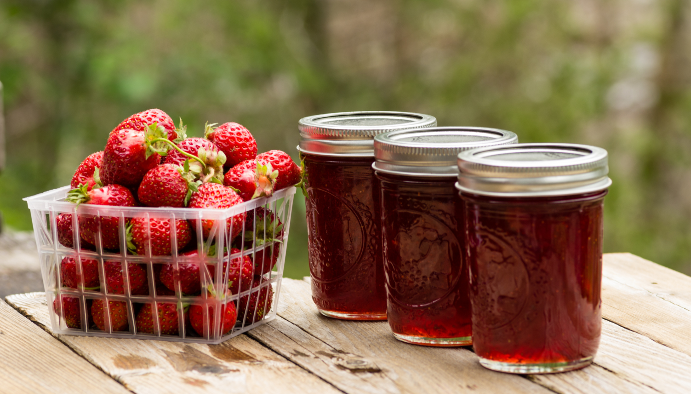 Strawberries in a basket and canned strawberry jam