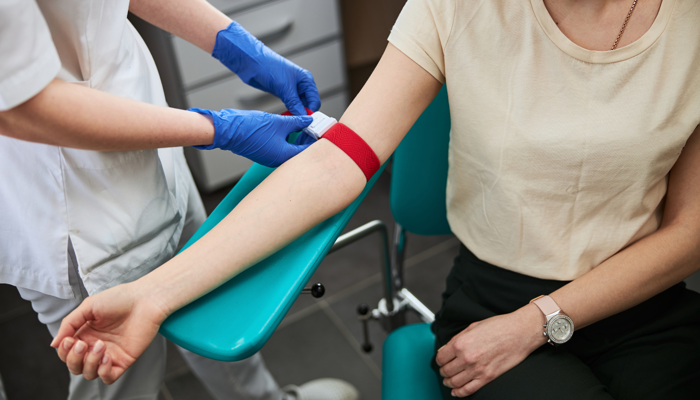 Pictured is a Phlebotomist taking blood from a patient.