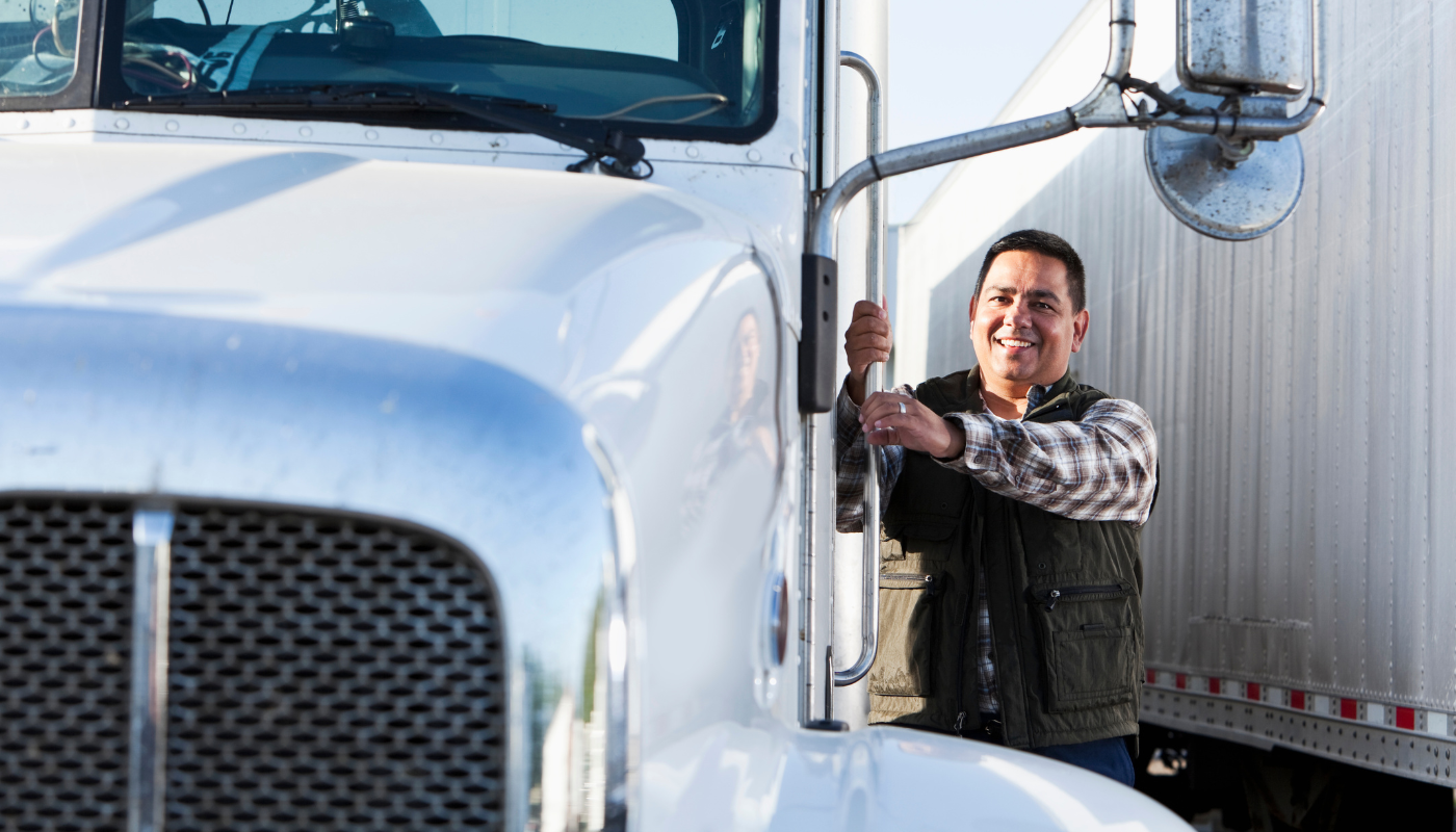 A truck driver getting into a truck.