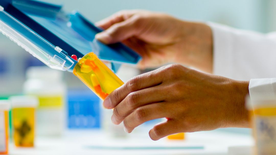 Pictured is a pharmacy technician counting prescriptions. 