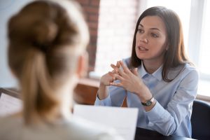 Confident focused businesswoman speaking to people at business negotiations