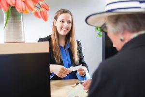 Bank Teller Service with Customer Deposit Transaction Over Business Counter