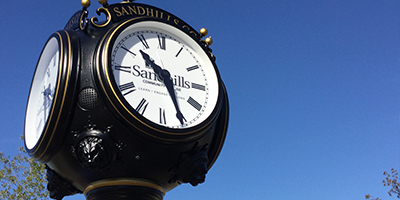 SCC clock with blue sky in background.