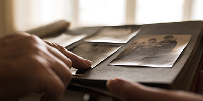 Close up of hands pointing to old photographs.