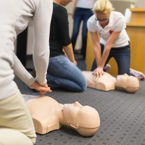 Students practicing CPR on mannequin.