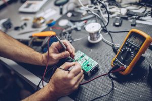 Repairman Checking Voltage With Digital Multimeter.
