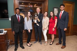 Raymond Villalobos poses for a photo with Sen. Thom Tillis, who's holding his pet, four other interns.