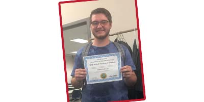 Thad Cagle proudly displays his recently earned High School Equivalency (HSE) diploma earned through the Sandhills Community College HSE in the Community program.