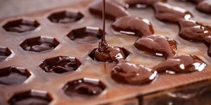 Close up of chocolate being poured into a mold.